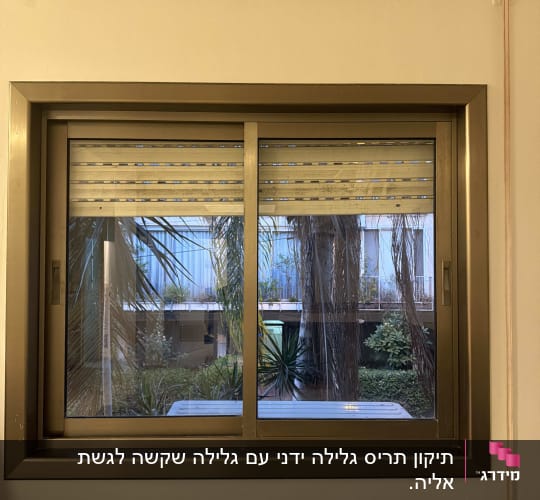 חלון עם תריס גלילה ומזגן מעליו